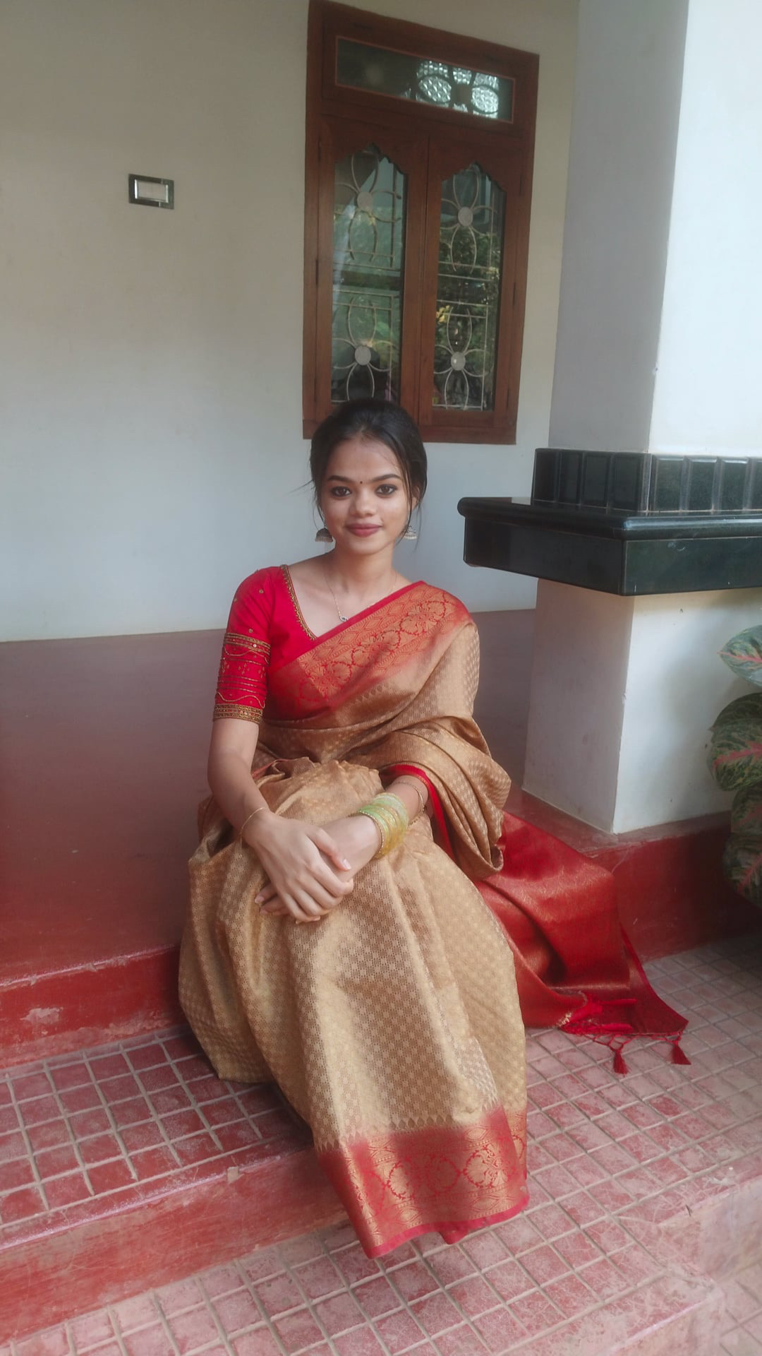 Punnya wearing a gold and red saree